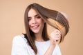 Girl combing hair. Beautiful young woman holding comb straightened hair. Attractive smiling woman portrait with comb. Royalty Free Stock Photo