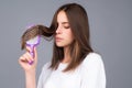 Girl combing hair. Beautiful young woman holding comb straightened hair. Royalty Free Stock Photo