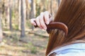 Girl combing hair with a wooden comb in the forest Royalty Free Stock Photo