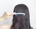 Girl combs long black hair comb, rear view, white background attractive Royalty Free Stock Photo