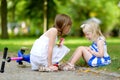 A girl comforting her sister after she fell while riding her scooter Royalty Free Stock Photo