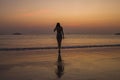 Girl coming out of the sea on the background of sunrise and sunset sun rays shadow