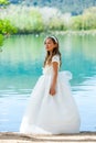 Girl in communion dress at lake.