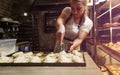 a girl cook in a cafe sprinkles coconut shavings on raw pies lying on a tray. open kitchen cooking