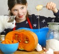 Girl cooking pie from flour pumpkin eggs