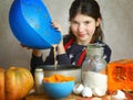 Girl cooking pie from flour pumpkin eggs