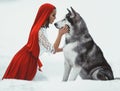 Girl in costume Little Red Riding Hood with dog malamute like a Royalty Free Stock Photo