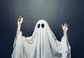 Girl in costume Spooky white ghost with black eyes on a gray background. Halloween minimal concept Royalty Free Stock Photo