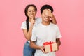 Girl covering her boyfriend`s eyes, showing silence sign Royalty Free Stock Photo