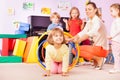 Girl crawl in plastic hoop, kindergarten group Royalty Free Stock Photo