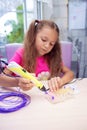 The girl creates toys using a 3D pen