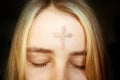 Girl with cross made from ash on forehead. Ash wednesday concept. Royalty Free Stock Photo
