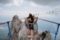 girl crosses a suspension bridge over a chasm at top of the Ai-Petri mountains in Crimea