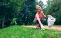 Girl picking up trash doing plogging Royalty Free Stock Photo