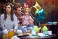 Girl with crown at head enjoying at birthday party with family Royalty Free Stock Photo