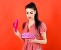 Girl with curious face, make up and pink box.