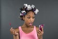 A girl with curlers in her hair looking at phone