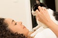 Girl with curly hair holding her lovely domestic black and white cat in bed. Concept of love to animals, pets, Royalty Free Stock Photo
