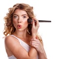 Girl with curly hair straightens makeup brush. Royalty Free Stock Photo