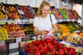 Girl customer buying red pepper at grocery shop Royalty Free Stock Photo