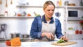 Girl cut finger by accident while slicing cucumber in kitchen, household injury Royalty Free Stock Photo