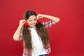 Girl cute child with hearts. Kid girl with long hair red background. Celebrate valentines day. Playful baby hold hearts Royalty Free Stock Photo