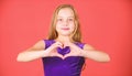 Girl cute child show heart shaped hand gesture. Symbol of love. Kid adorable girl with long hair smiling face show heart Royalty Free Stock Photo