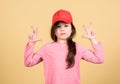 Girl cute child wear cap or snapback hat beige background. Little girl wearing bright baseball cap. Modern fashion. Kids