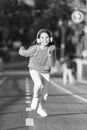 Girl cute with headphones. Little child enjoy activity. Kid walking running in park listening music. Music fills me with Royalty Free Stock Photo