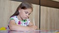 A girl or cute primary child school child painting or writening on paper.