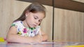 A girl or cute primary child school child painting or writening on paper.