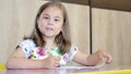 A girl or cute primary child school child painting or writening on paper.