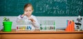 Girl cute pupil play with test tubes and colorful liquids. School chemical experiment. School education. Interesting Royalty Free Stock Photo