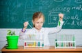 Girl cute school pupil play with test tubes and colorful liquids. School chemical experiment. School education