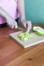 Girl cuts apples with a knife on a wooden Board in the kitchen Royalty Free Stock Photo