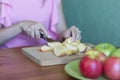 Girl cuts apples with a knife on a wooden Board in the kitchen Royalty Free Stock Photo