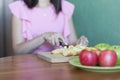 Girl cuts apples with a knife on a wooden Board in the kitchen