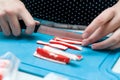 The girl cuts fish sticks for sushi into boards