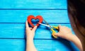 girl cuts the heart with scissors, the concept of breaking relations, quarrels and divorce. Betrayal of the othere. blue back Royalty Free Stock Photo