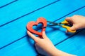 Girl cuts the heart with scissors, the concept of breaking relations, quarrels and divorce. Betrayal of the othere. blue backgroun Royalty Free Stock Photo