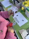 A small girl cuts paper with scissors at a collage workshop Royalty Free Stock Photo
