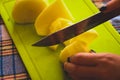 The girl cuts potatoes on a cutting board with a knife. Royalty Free Stock Photo