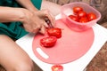 Girl cuts a tomato knife Royalty Free Stock Photo