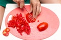 Girl cuts a tomato knife Royalty Free Stock Photo