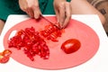 Girl cuts a tomato knife Royalty Free Stock Photo