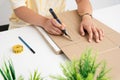 Girl cutting cardboard with a cutter on a thick white surface near the house plants Royalty Free Stock Photo