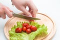 Girl is cutting cherry tomatoes Royalty Free Stock Photo