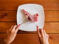 Girl cutting of raw pork steak
