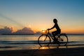 Girl cycling in the sea during sunrise