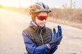 Girl cyclist puts on sports gloves. Teenage girl in protective bicycle helmet, glasses and gloves Royalty Free Stock Photo